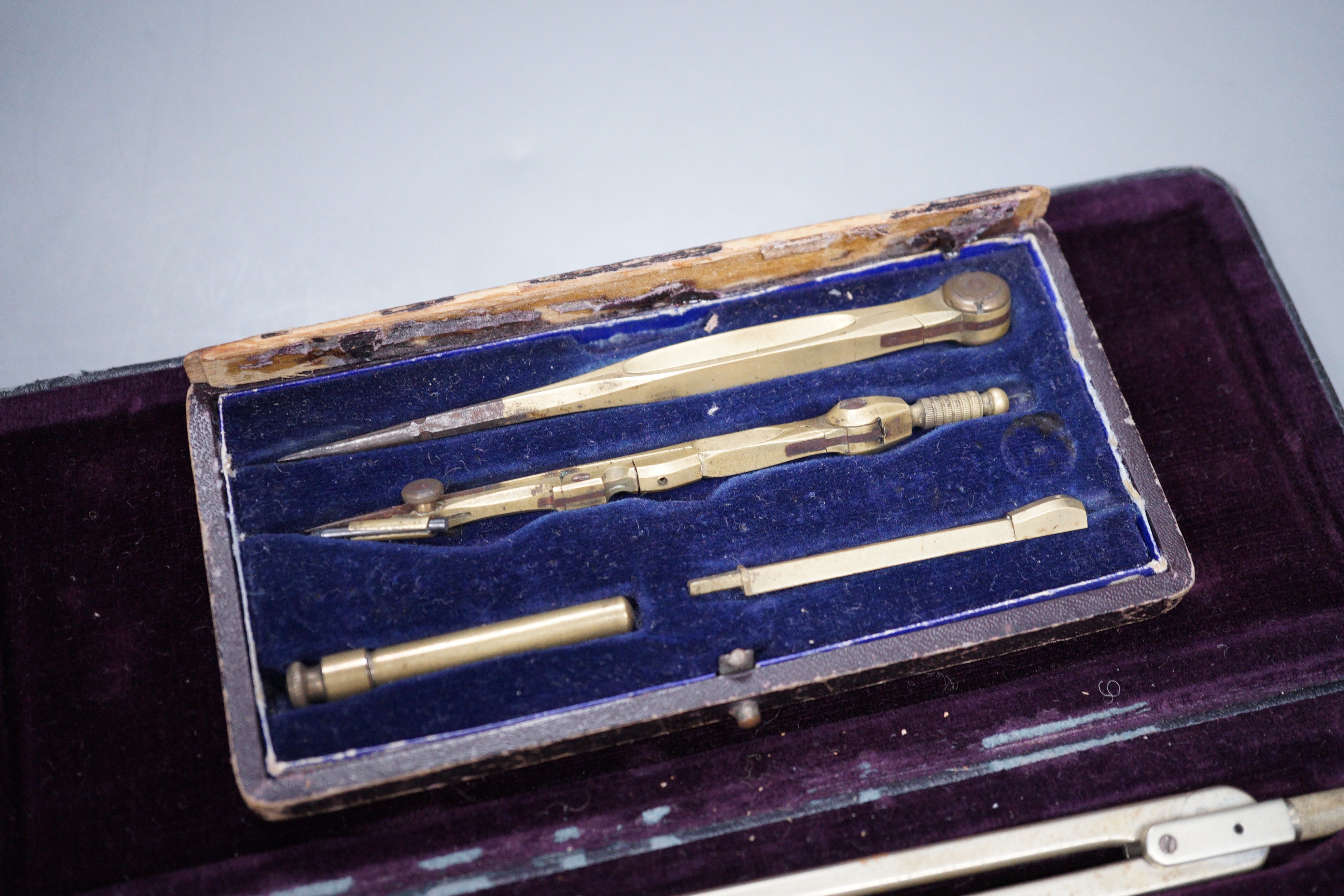 Two cased drawing sets and a Roman oil lamp